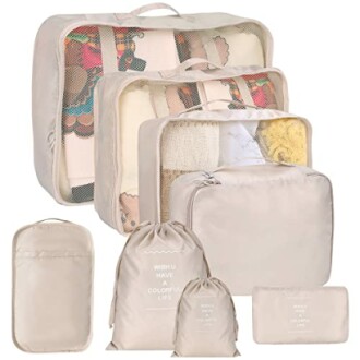 Set of beige travel packing cubes and bags with mesh tops.