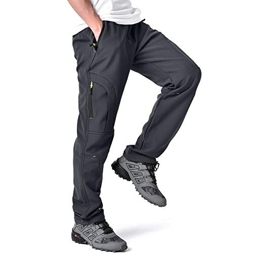 Man wearing black hiking pants with zippered pockets and hiking shoes.