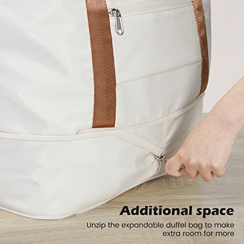 Hand unzipping an expandable duffel bag for extra space.