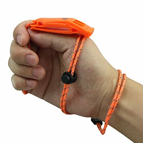 Hand holding an orange safety whistle with a wrist strap.