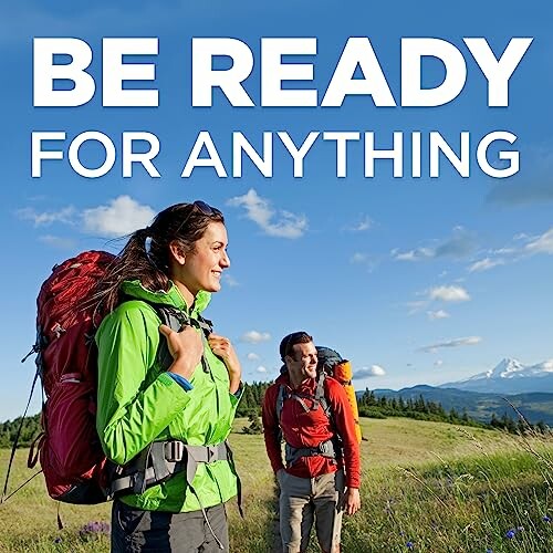 Two hikers with backpacks in a scenic mountain landscape under a blue sky.