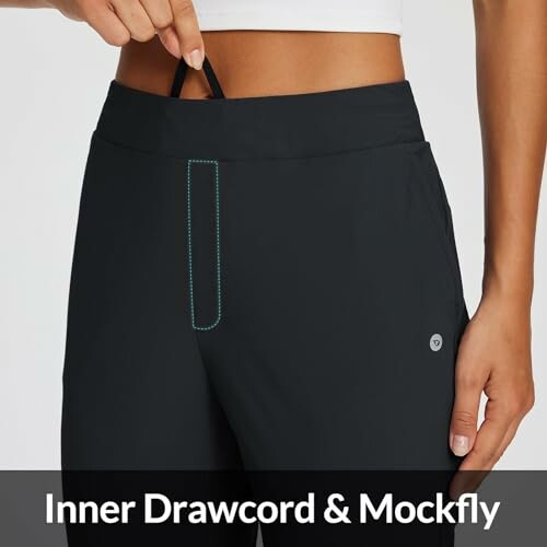 Person showing inner drawcord and mockfly on black pants.