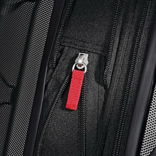 Close-up of a black luggage with a red zipper pull.