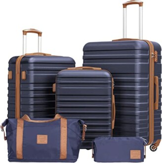 Set of navy blue luggage with brown accents including suitcases and bags.