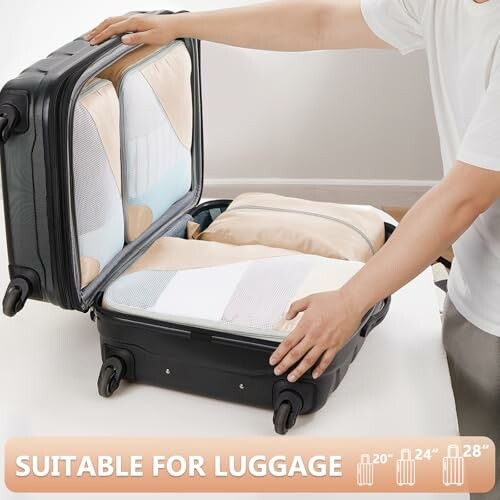 Person organizing clothes in a suitcase with packing cubes.