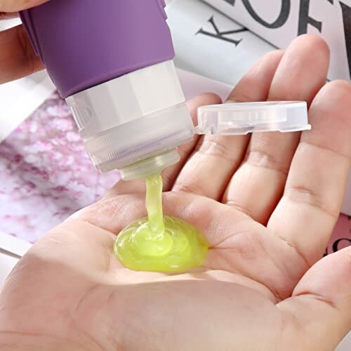 Travel bottle dispensing green liquid onto hand