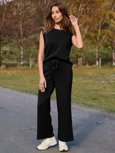 Woman in black outfit standing outdoors on a path